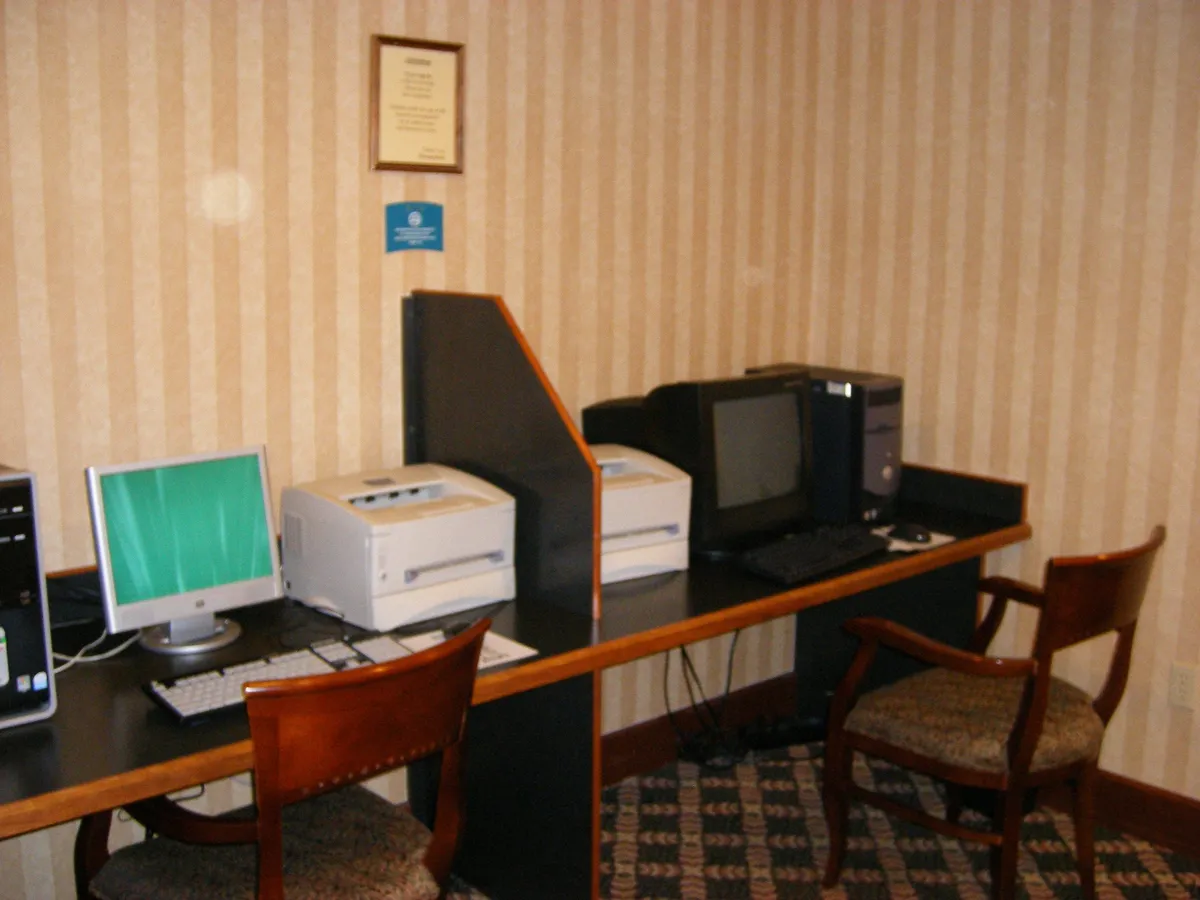 A well-appointed business center featuring computers, printers, comfortable chairs, and tasteful wall decor. The space is designed for productivity and convenience, offering guests a quiet, focused environment for work or personal tasks.